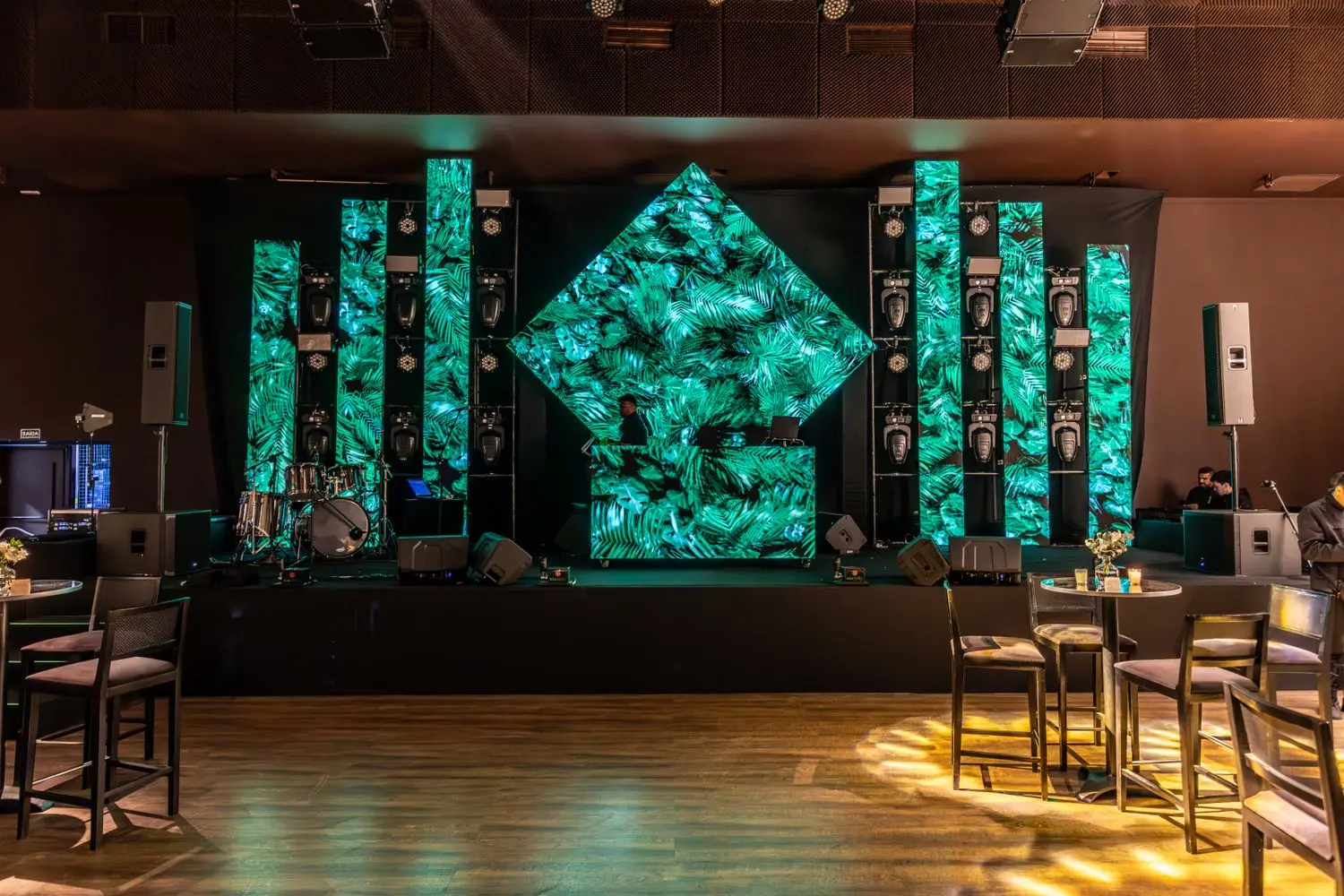 Large event room arranged with distinct zones and stage area